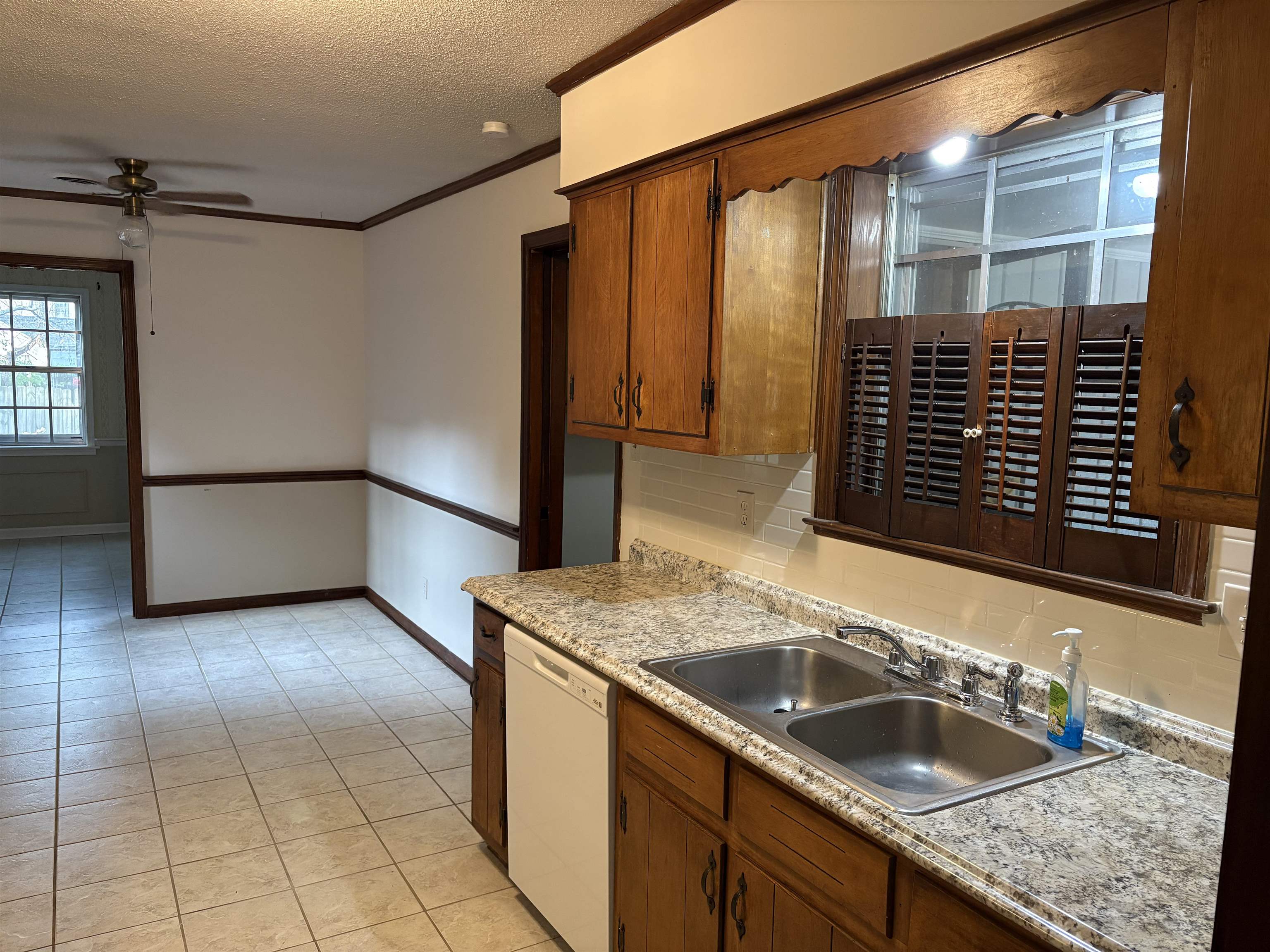 5459 Knight Arnold Road Memphis, TN 38115 - Photo 15 of 38 Kitchen with decorative backsplash, crown molding, ceiling fan, a textured ceiling, and wood finish cabinets