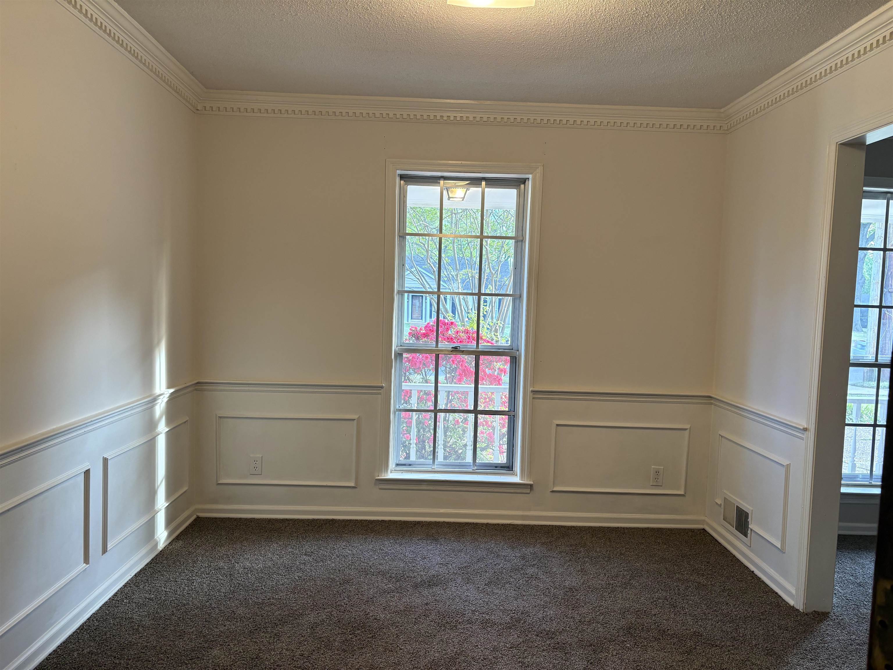5459 Knight Arnold Road Memphis, TN 38115 - Photo 5 of 38 Spare room with crown molding, a textured ceiling, wainscoting, a decorative wall, and dark colored carpet