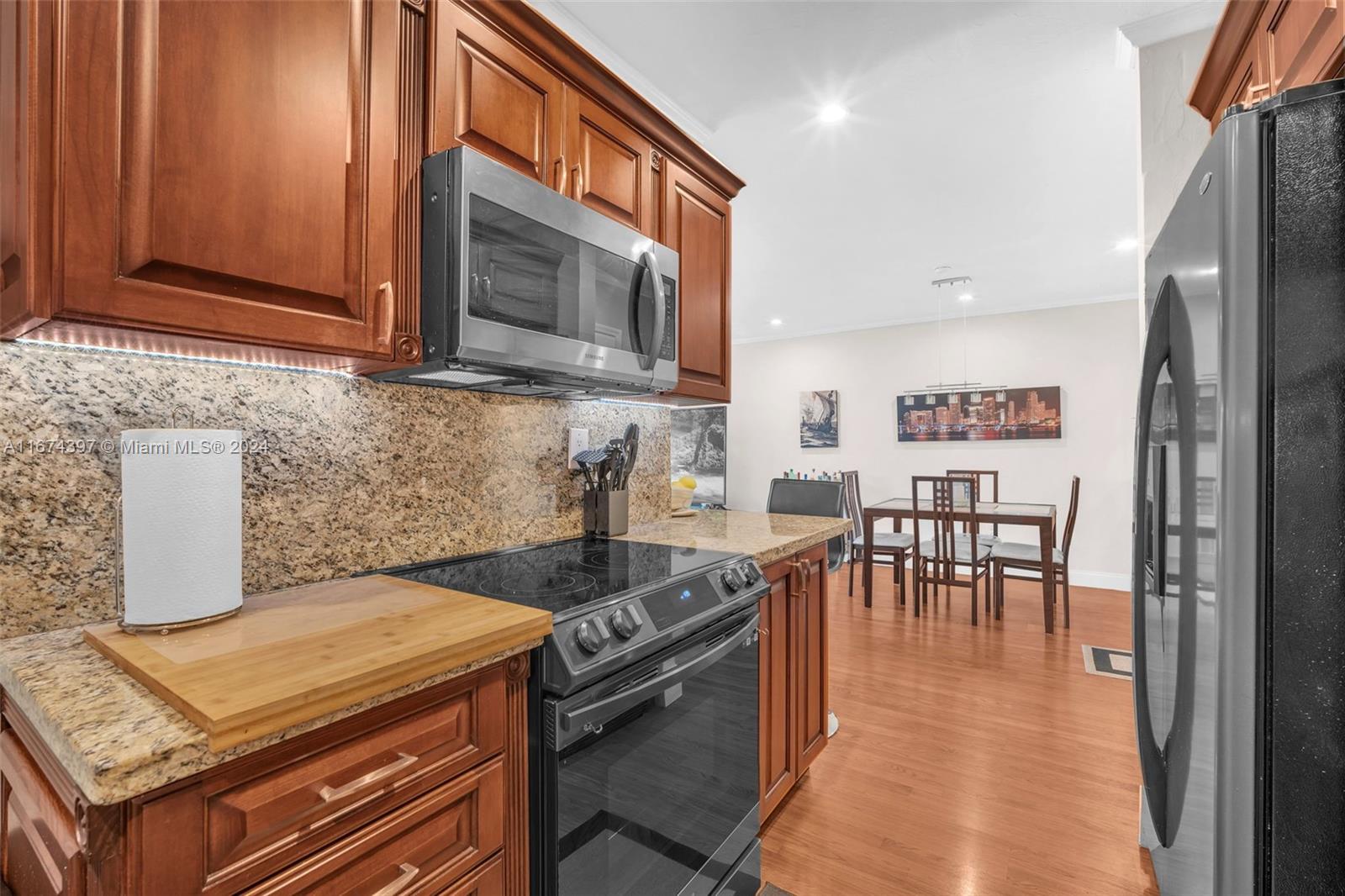 8335 Southwest 72nd Avenue, Unit 312D Miami, FL 33143 - Photo 21 of 45 a kitchen with stainless steel appliances granite countertop a stove a sink and a microwave