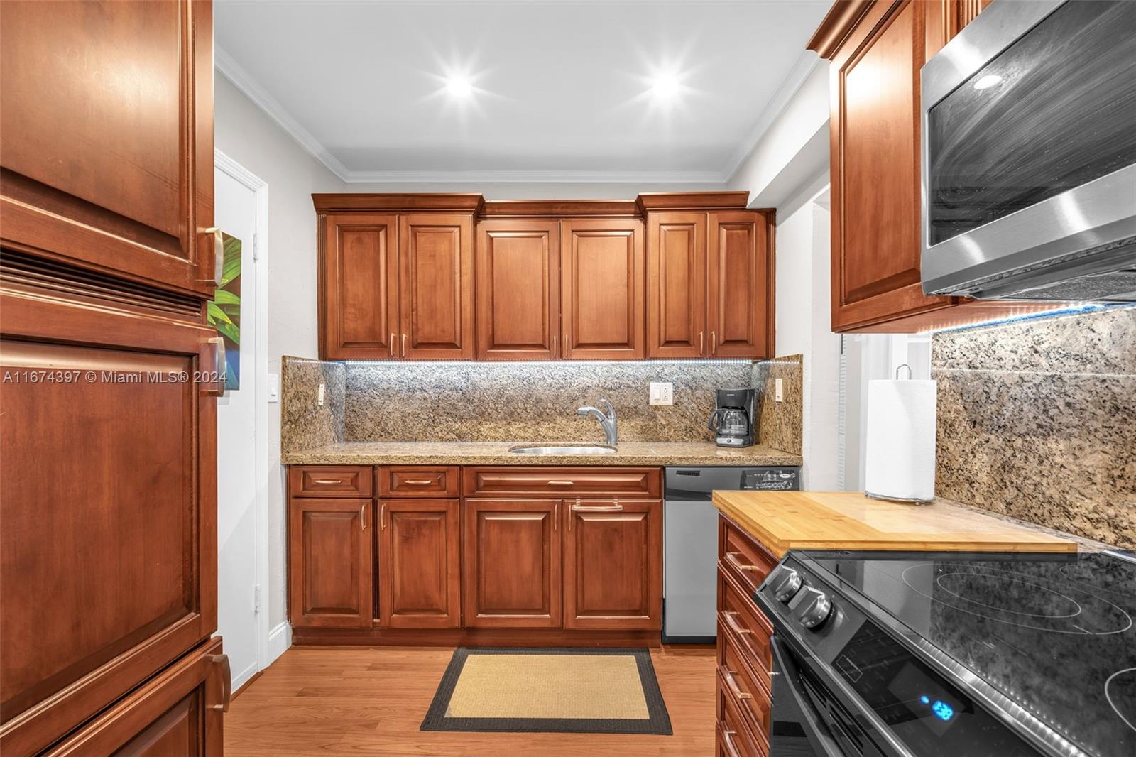 8335 Southwest 72nd Avenue, Unit 312D Miami, FL 33143 - Photo 3 of 45 a kitchen with a sink stove and cabinets