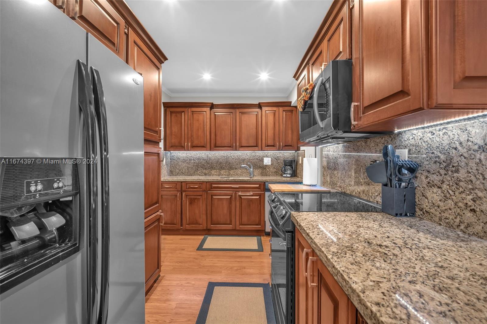 8335 Southwest 72nd Avenue, Unit 312D Miami, FL 33143 - Photo 4 of 45 a kitchen with stainless steel appliances granite countertop a refrigerator a stove and a sink