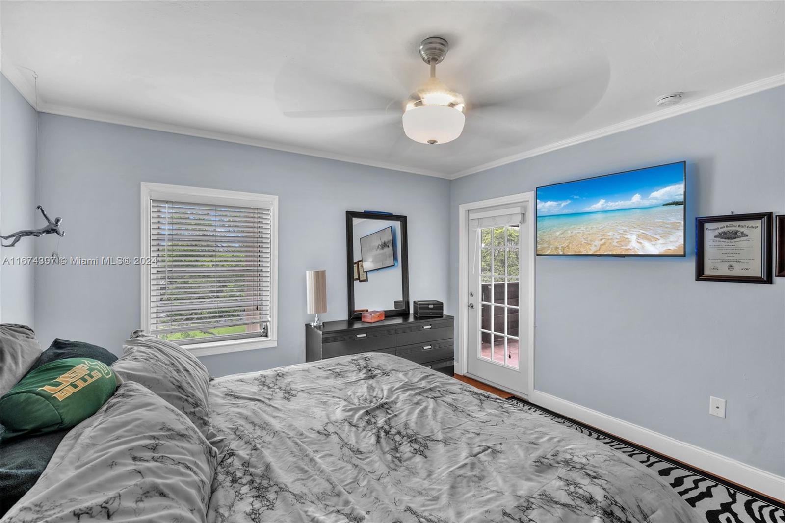 8335 Southwest 72nd Avenue, Unit 312D Miami, FL 33143 - Photo 8 of 45 a bedroom with a bed and a dresser with mirror