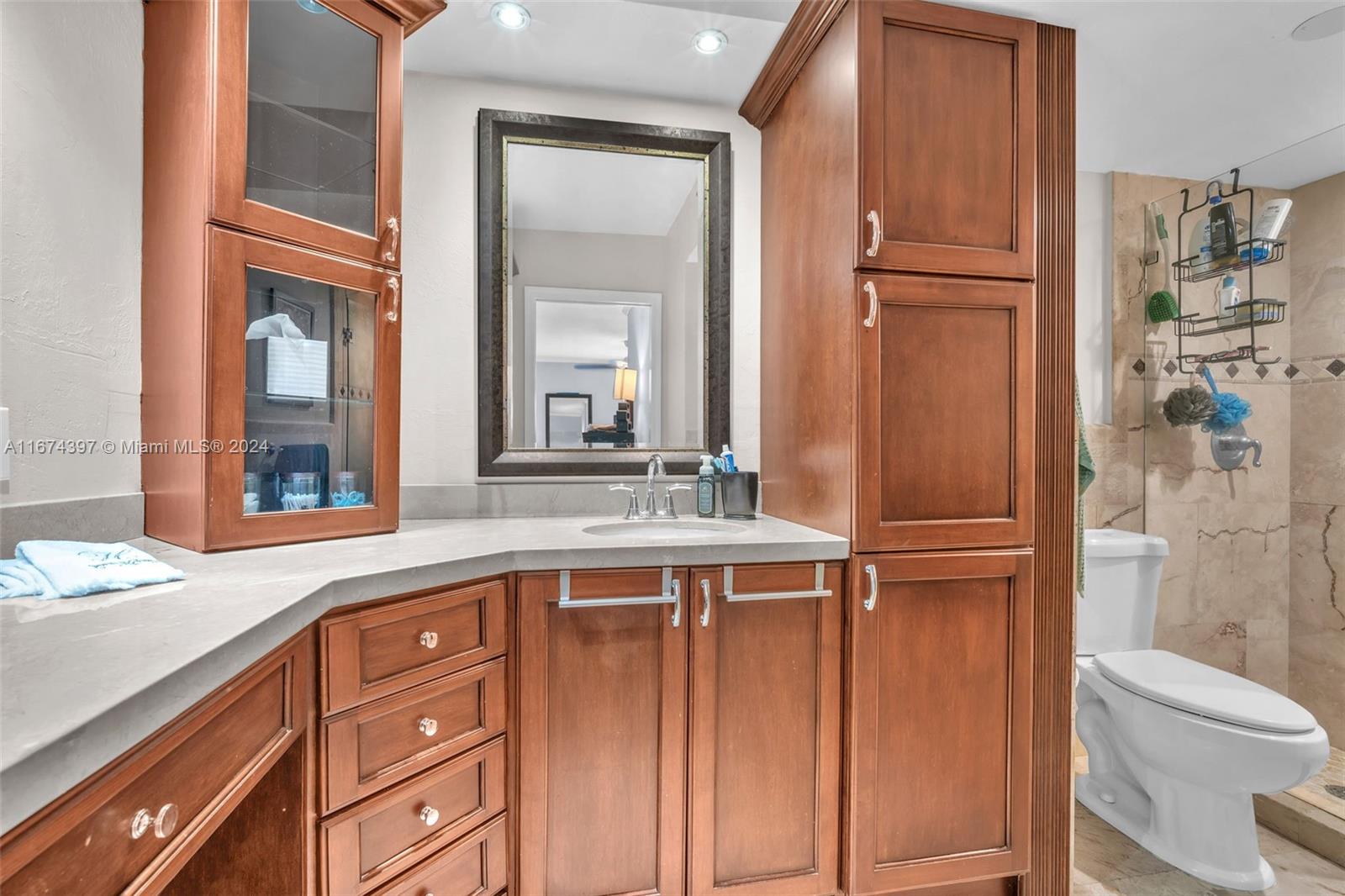 8335 Southwest 72nd Avenue, Unit 312D Miami, FL 33143 - Photo 9 of 45 a bathroom with a sink a toilet and a mirror
