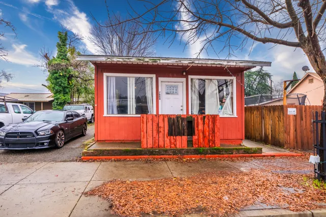 a view of a house with a small yard and wooden fence