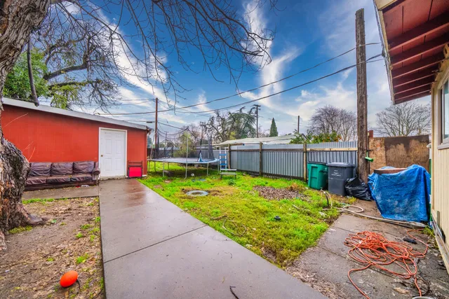 a backyard of a house with barbeque oven and a table and chairs