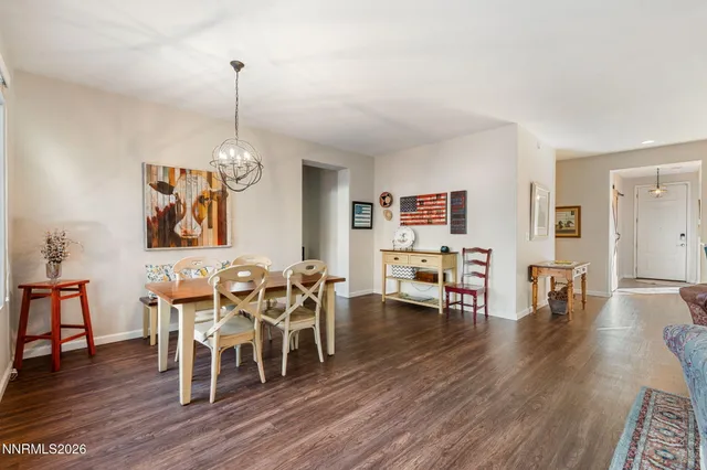 a view of a dining room and livingroom with furniture wooden floor a chandelier