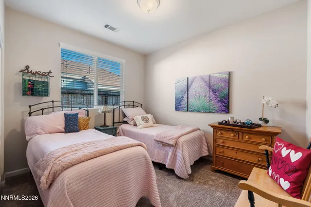a bedroom with two beds and a chandelier
