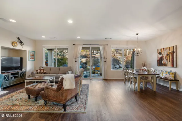 a living room with furniture a rug a flat screen tv and a large window