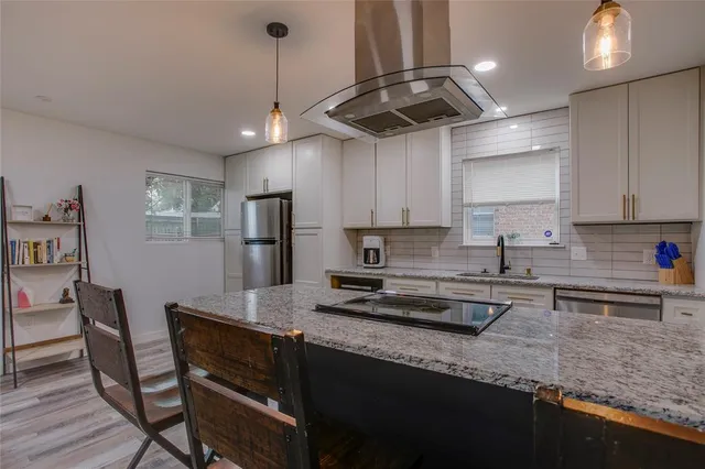 a kitchen with stainless steel appliances granite countertop a sink refrigerator and cabinets
