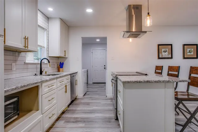 a kitchen with granite countertop a sink and cabinets