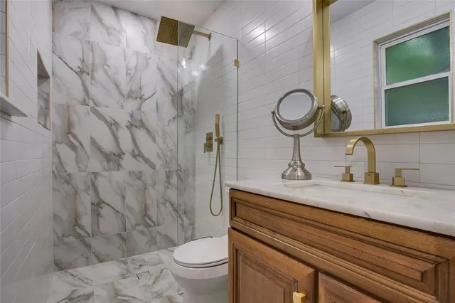 a bathroom with a sink a toilet and shower