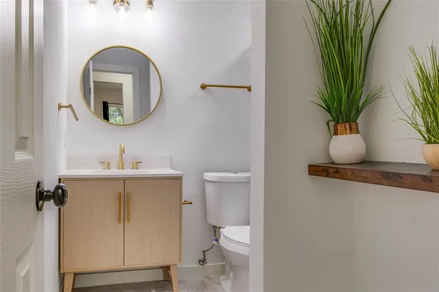 a bathroom with a toilet a sink and a mirror