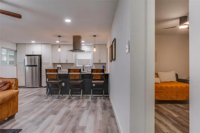 a dining room with stainless steel appliances furniture a refrigerator and kitchen view
