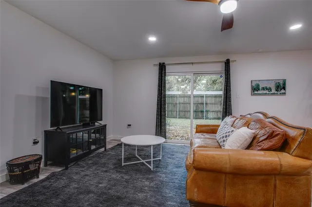 a living room with furniture a flat screen tv and a window