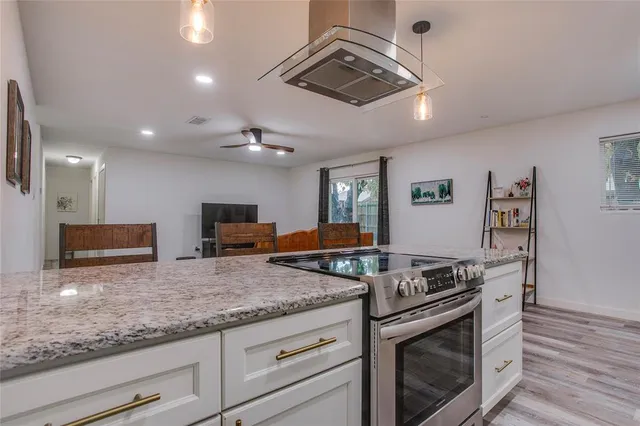 a kitchen with granite countertop stainless steel appliances a stove microwave and cabinets