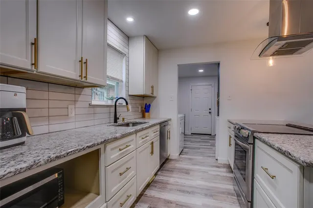 a kitchen with granite countertop a sink and cabinets