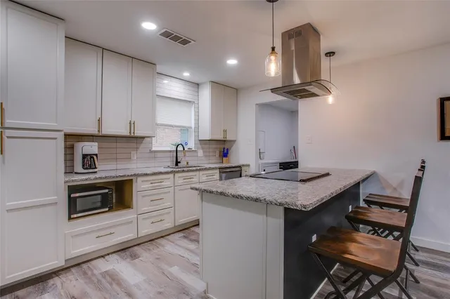a kitchen with a stove cabinets and wooden floor