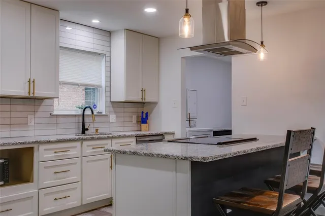 a kitchen with stainless steel appliances granite countertop a sink a stove and a refrigerator