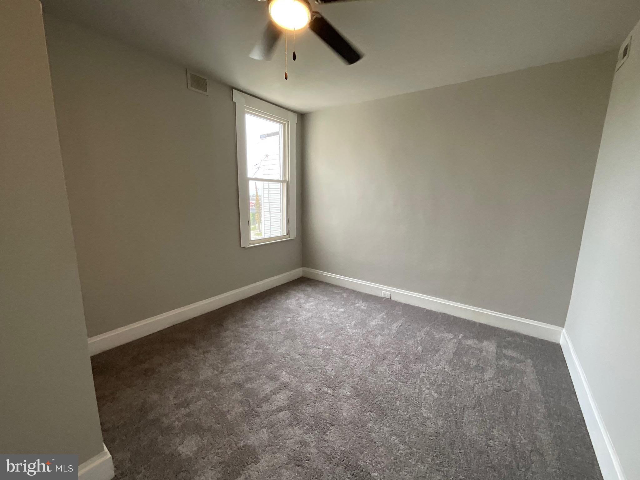 4415 Pimlico Road Baltimore, MD 21215 - Photo 12 of 18 an empty room with a window and a fan