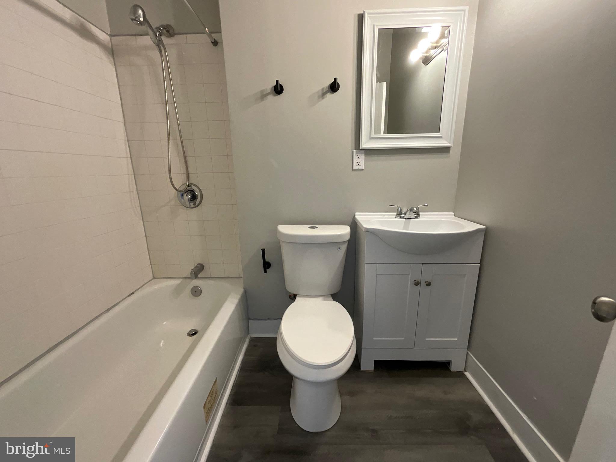 4415 Pimlico Road Baltimore, MD 21215 - Photo 8 of 18 a bathroom with a toilet sink and mirror