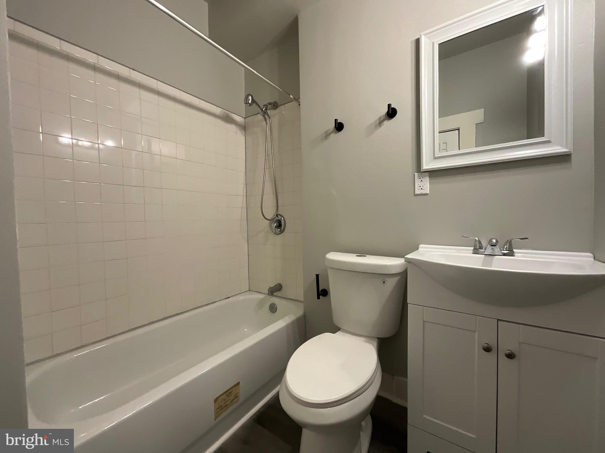 4415 Pimlico Road Baltimore, MD 21215 - Photo 9 of 18 a bathroom with a sink toilet and shower