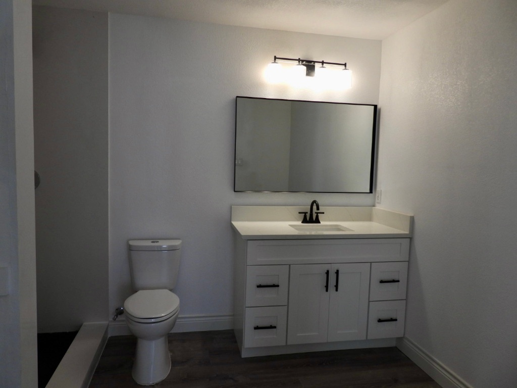 1619 Rutland Drive, Unit A Austin, TX 78758 - Photo 13 of 14 a bathroom with a toilet sink and mirror