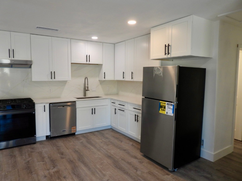 1619 Rutland Drive, Unit A Austin, TX 78758 - Photo 3 of 14 a kitchen with a refrigerator sink and white cabinets