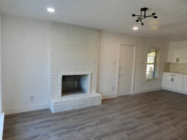 a view of a livingroom with a fireplace and wooden floor