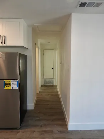 a view of a hallway with wooden floor