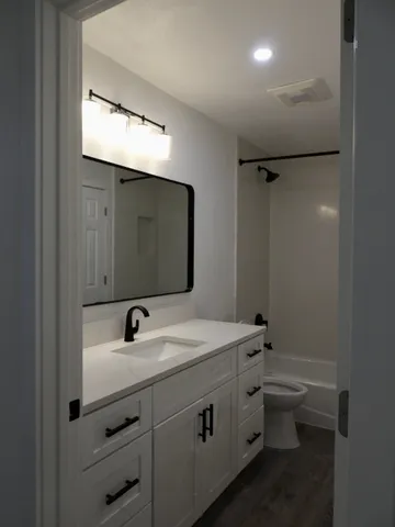 a bathroom with a double vanity sink toilet and mirror