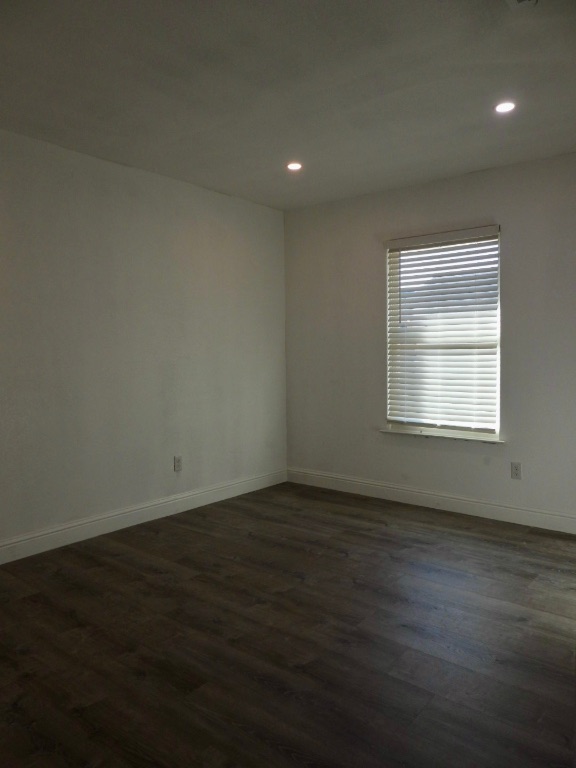 1619 Rutland Drive, Unit A Austin, TX 78758 - Photo 8 of 14 a view of an empty room with wooden floor and a window