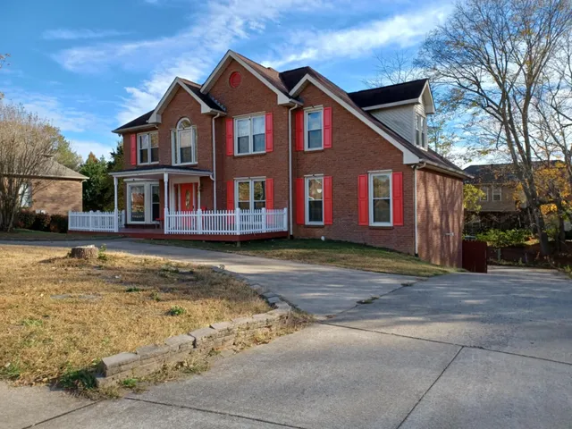 a view of a white house with large windows next to a road