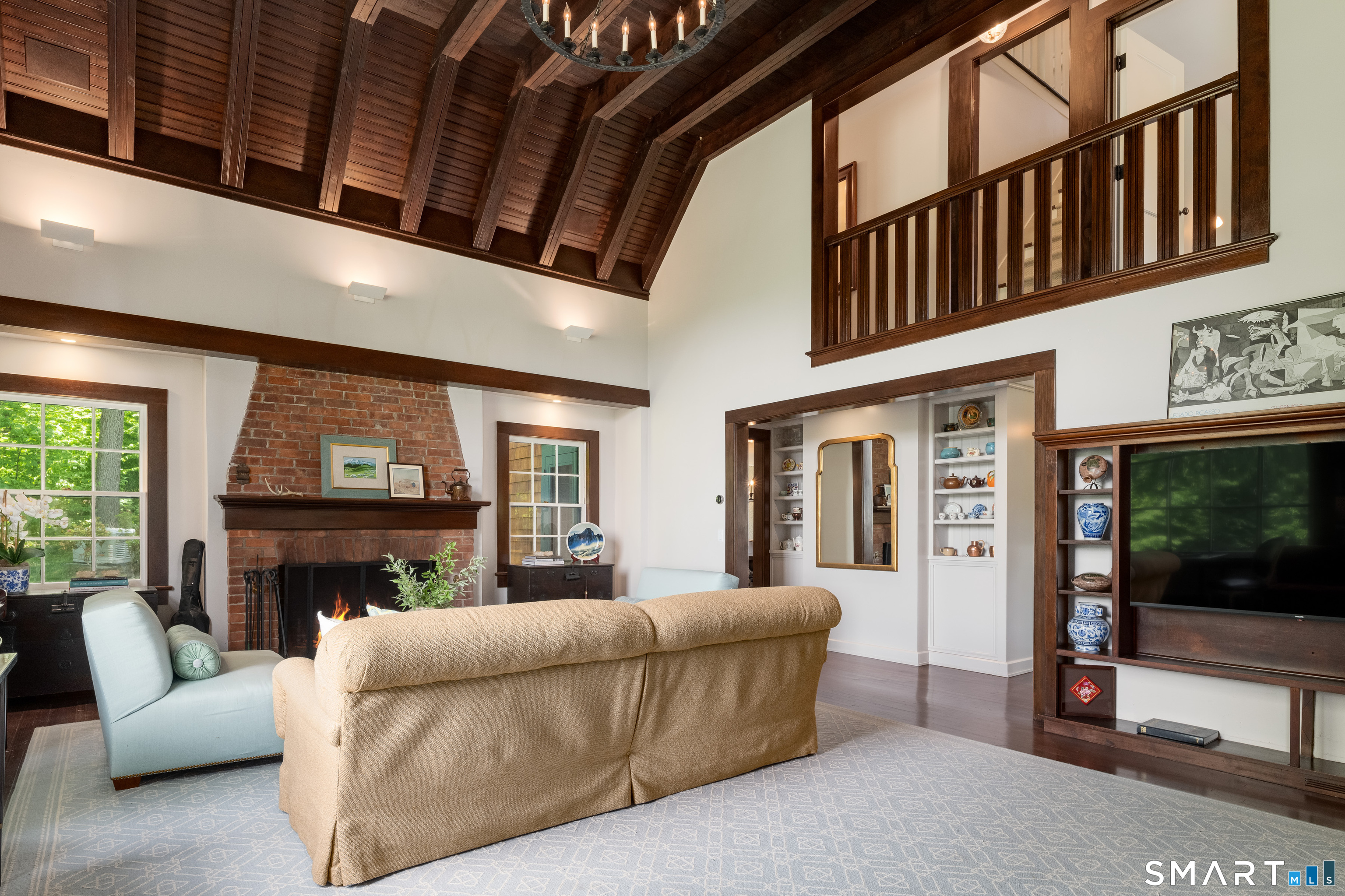 240 Umpawaug Road Redding, CT 06896 - Photo 9 of 40 Original hardwood flooring, ceiling, stairs and railing, wood-burning fireplace, vintage chandelier and built-in entertainment wall - a perfect gathering space for family and friends.