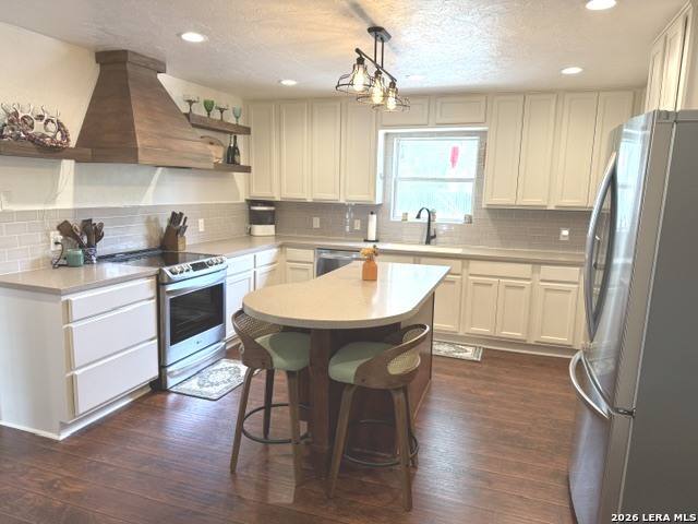 908 29th Street Hondo, TX 78861 - Photo 12 of 37 a kitchen with a sink a refrigerator a stove and white cabinets with wooden floor