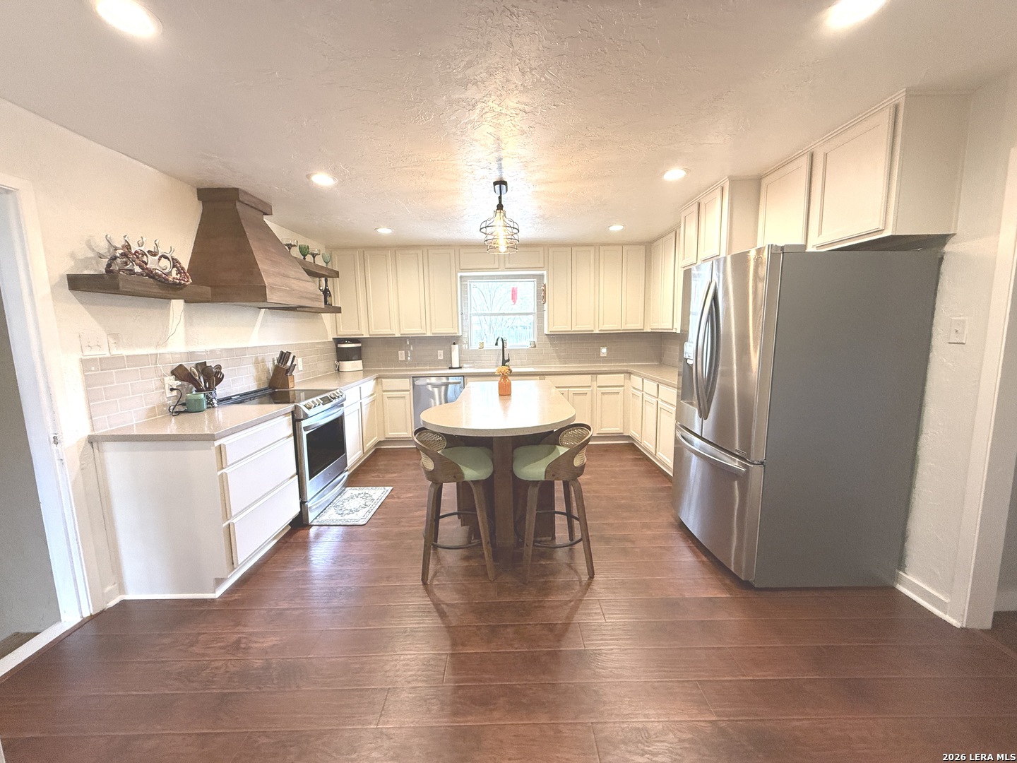 908 29th Street Hondo, TX 78861 - Photo 10 of 37 a kitchen with stainless steel appliances wooden floor and refrigerator