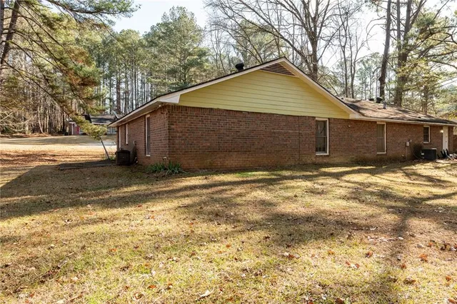 a front view of house with yard and trees in the background