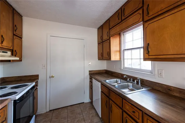 a kitchen with a sink stove and cabinets