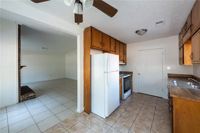 a kitchen with a refrigerator and a stove top oven