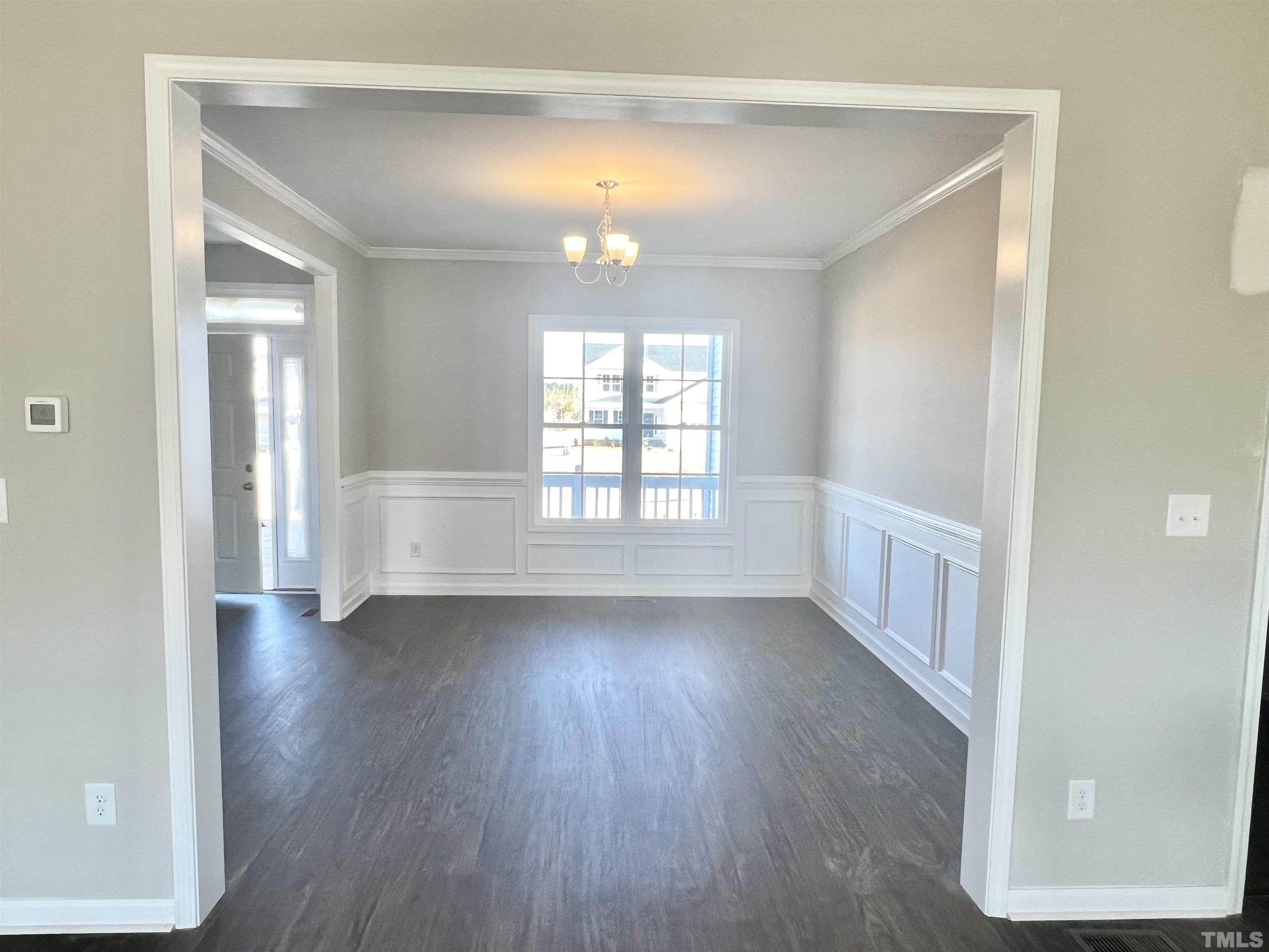 4432 Debnam Road Zebulon, NC 27597 - Photo 6 of 9 a view of an empty room with wooden floor and a window