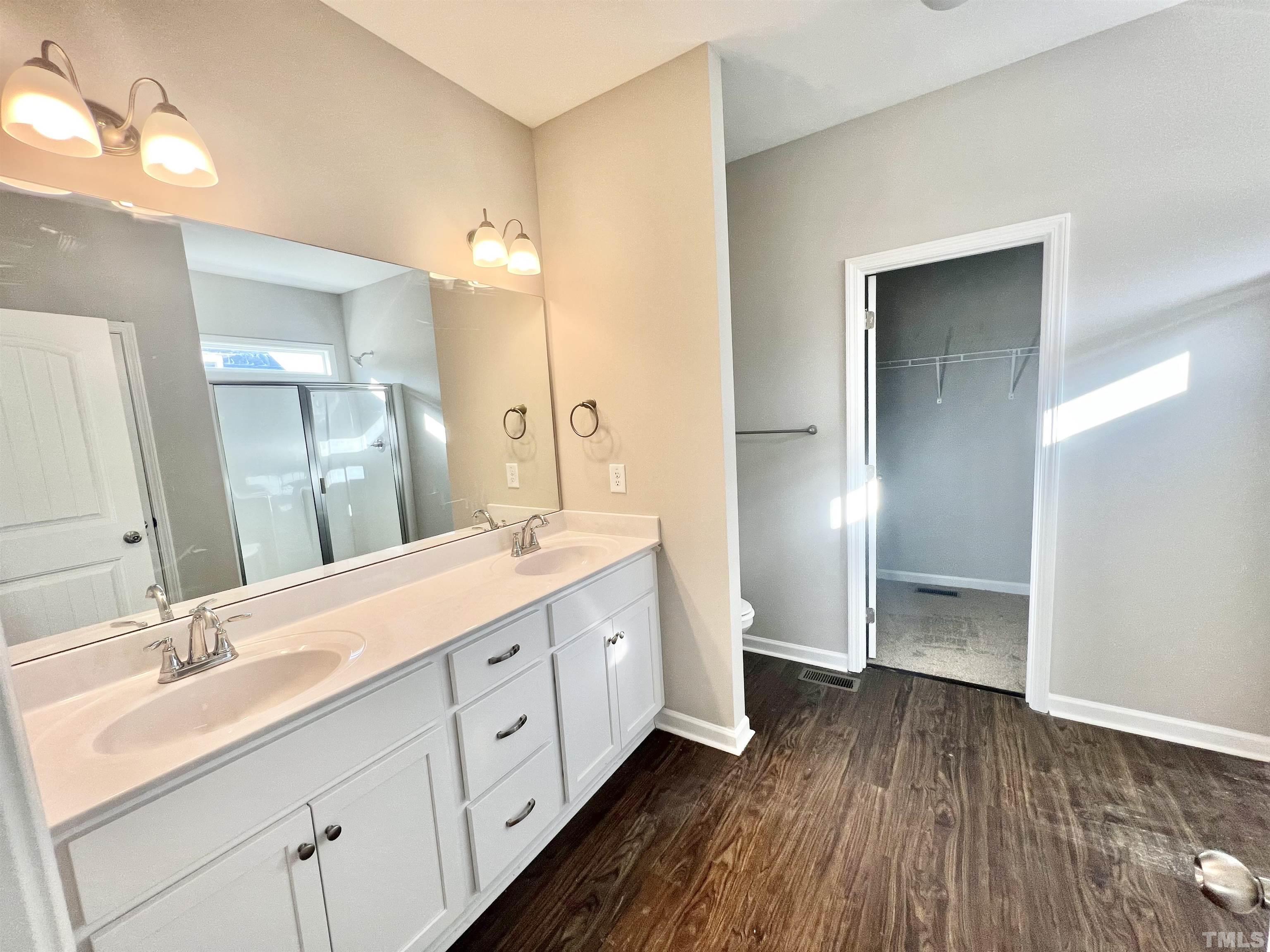 4432 Debnam Road Zebulon, NC 27597 - Photo 7 of 9 a spacious bathroom with a double vanity sink and a mirror