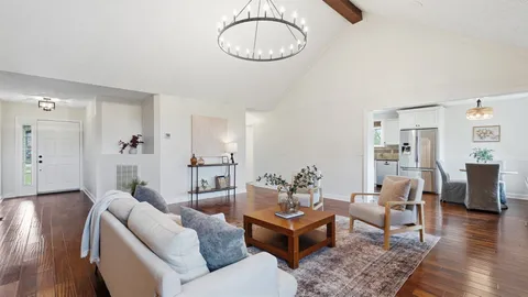 a living room with furniture a wooden floor and a chandelier