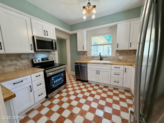 a bedroom with a bed window and dresser
