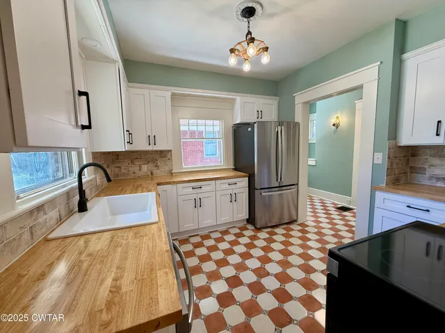 a kitchen with stainless steel appliances a sink and a refrigerator