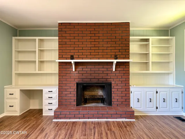 a view of a livingroom with a fireplace and wooden floor