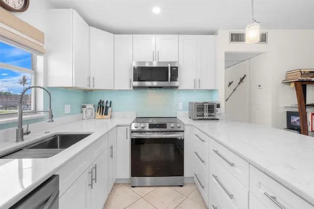 a kitchen with granite countertop white cabinets and white appliances