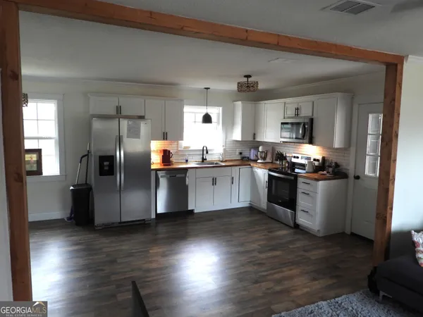 a kitchen with granite countertop stainless steel appliances a sink a refrigerator a stove a microwave and cabinets