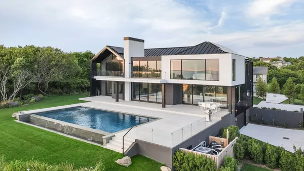 a view of a house with a big yard and large trees