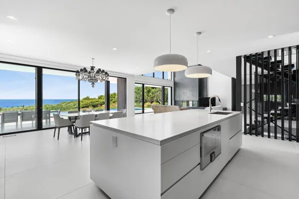 a large white kitchen with a large island in the center