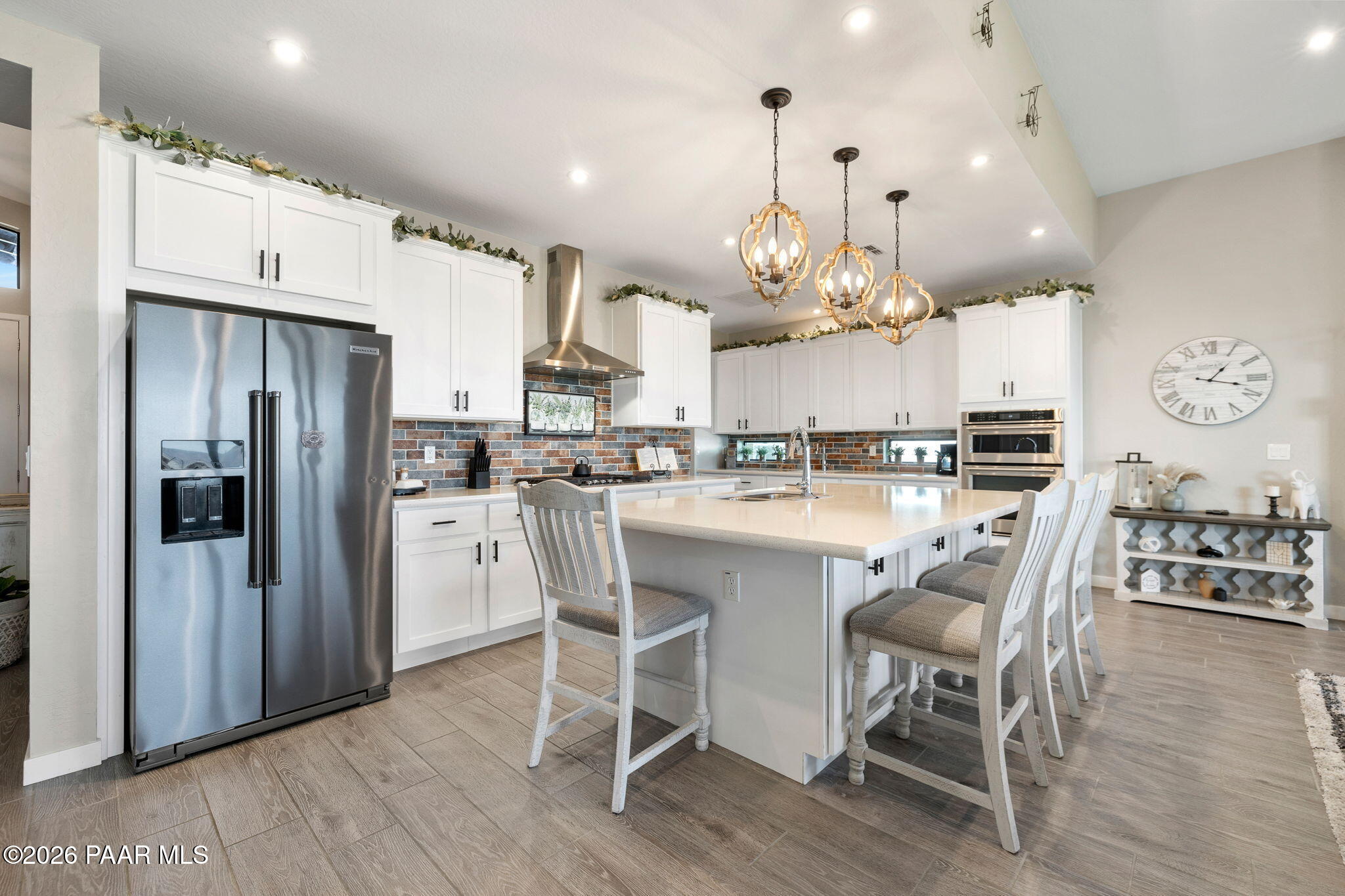 4882 North Yorkshire Loop Prescott Valley, AZ 86314 - Photo 8 of 28 a kitchen with stainless steel appliances kitchen island granite countertop a refrigerator a stove a kitchen island a dining table and chairs with wooden floor