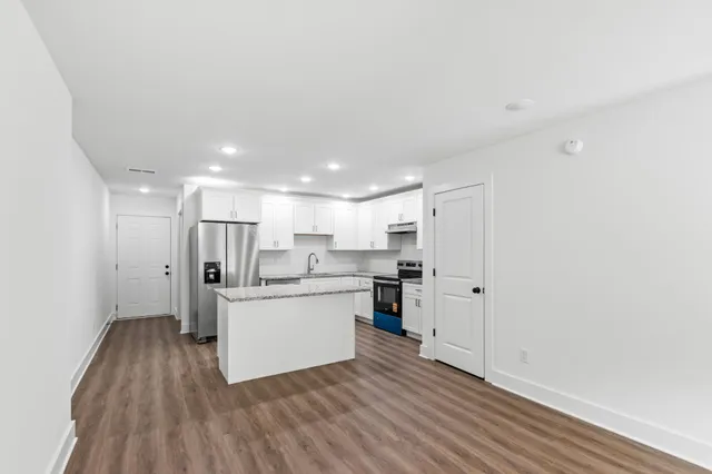 a view of a kitchen with wooden floor and electronic appliances